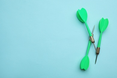 Photo of Green dart arrows on blue background, flat lay with space for text