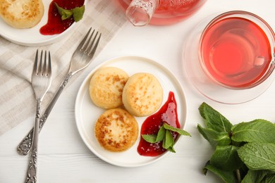 Photo of Delicious cottage cheese pancakes with jam and mint on white wooden table, flat lay