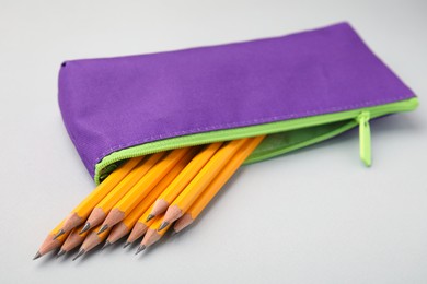 Many sharp pencils in pencil case on light grey background