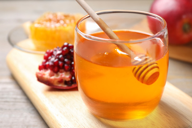 Photo of Honey, apples and pomegranate on table, closeup. Rosh Hashanah holiday