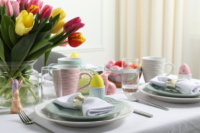 Photo of Easter celebration. Festive table setting with beautiful flowers and painted eggs