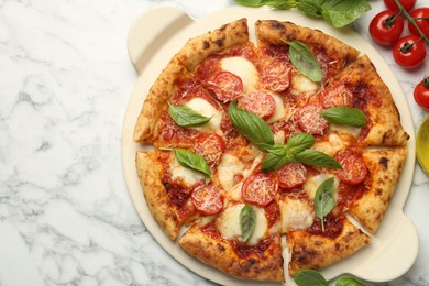 Photo of Delicious Margherita pizza and ingredients on white marble table, top view. Space for text