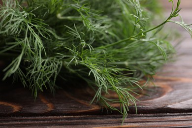 Photo of Fresh green dill on wooden table, closeup