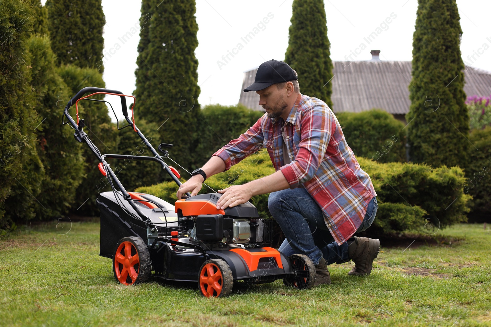 Photo of Man with modern lawn mower in garden