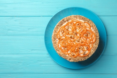 Dish with delicious carrot cake on blue wooden background, top view. Space for text