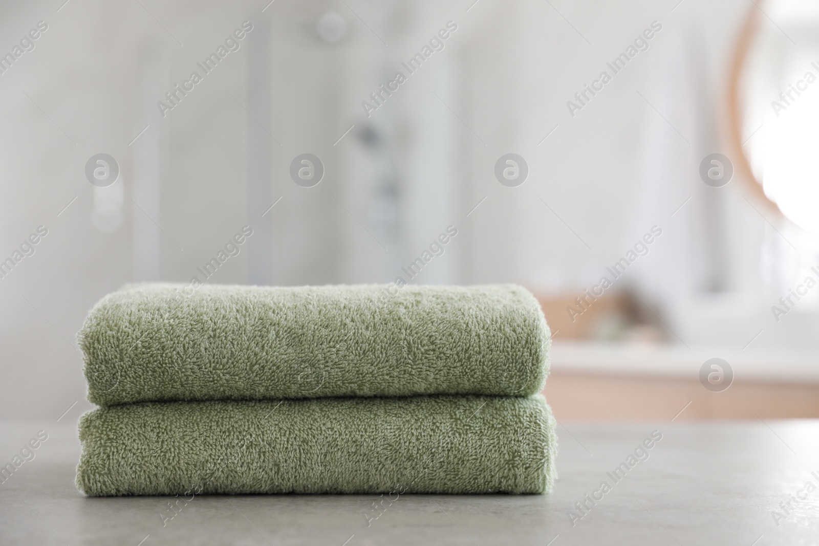 Photo of Stack of clean towels on table in bathroom