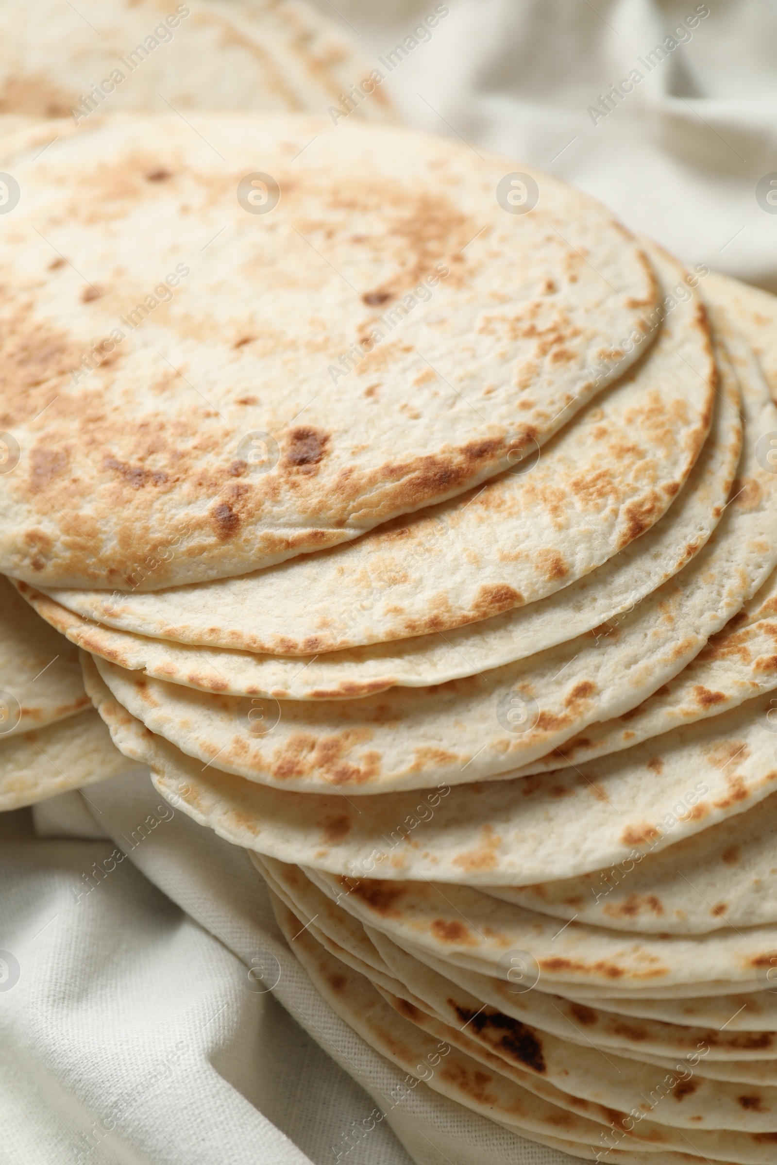 Photo of Tasty homemade tortillas and cloth on table