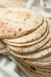 Tasty homemade tortillas and cloth on table