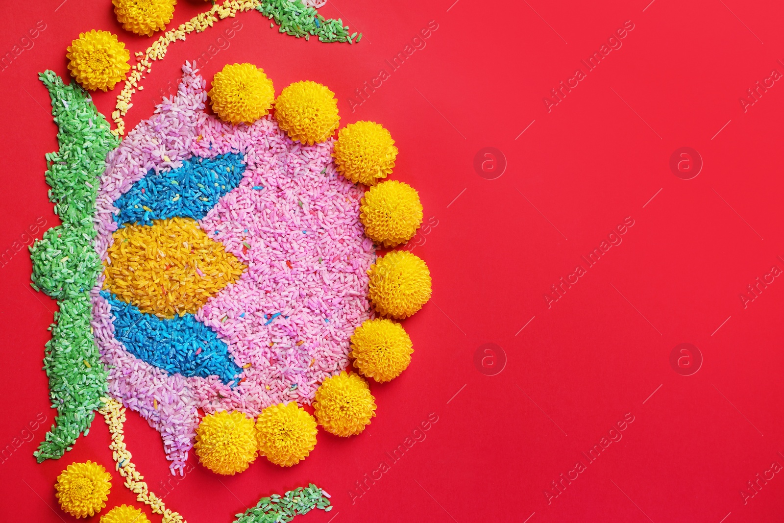 Photo of Happy Diwali. Composition with colorful rangoli and chrysanthemum flowers on red background, top view. Space for text