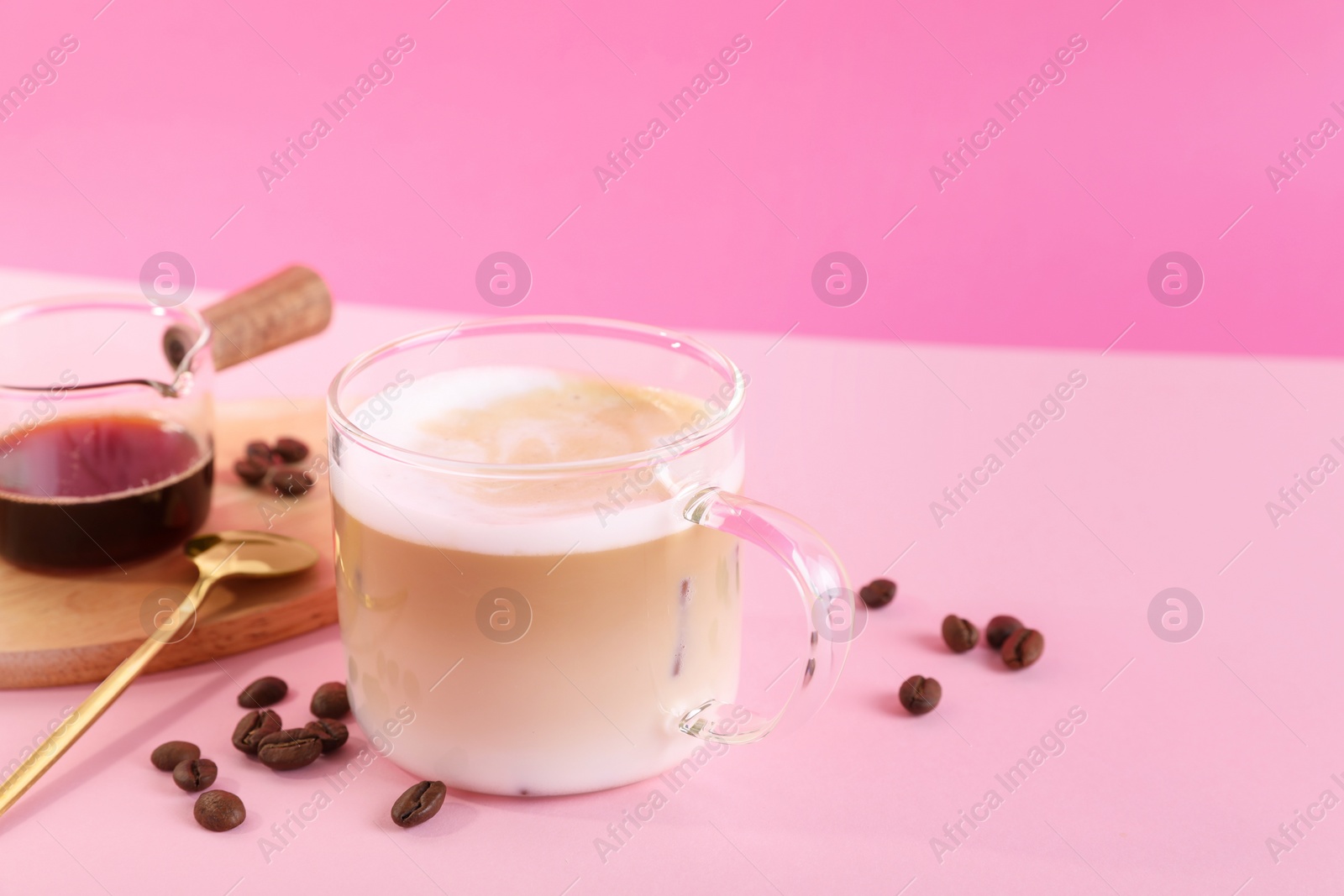 Photo of Cup of fresh coffee and beans on pink table. Space for text