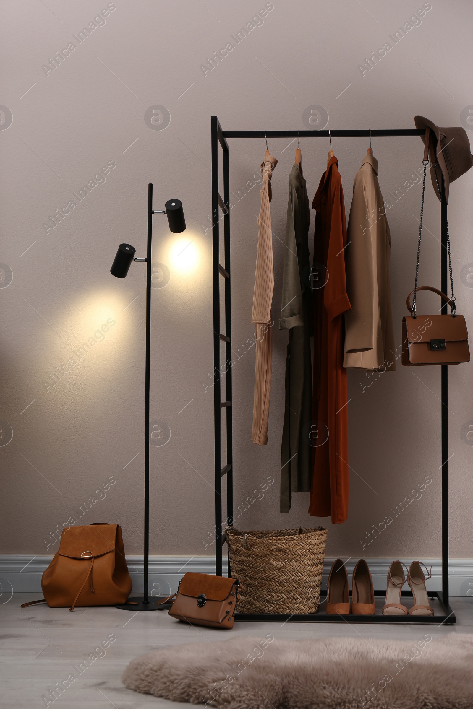 Photo of Modern dressing room interior with clothing rack near beige wall