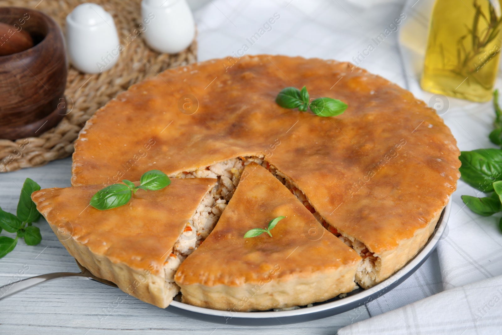 Photo of Delicious meat pie with basil on white table, closeup