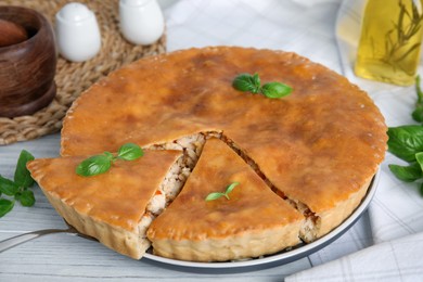 Delicious meat pie with basil on white table, closeup