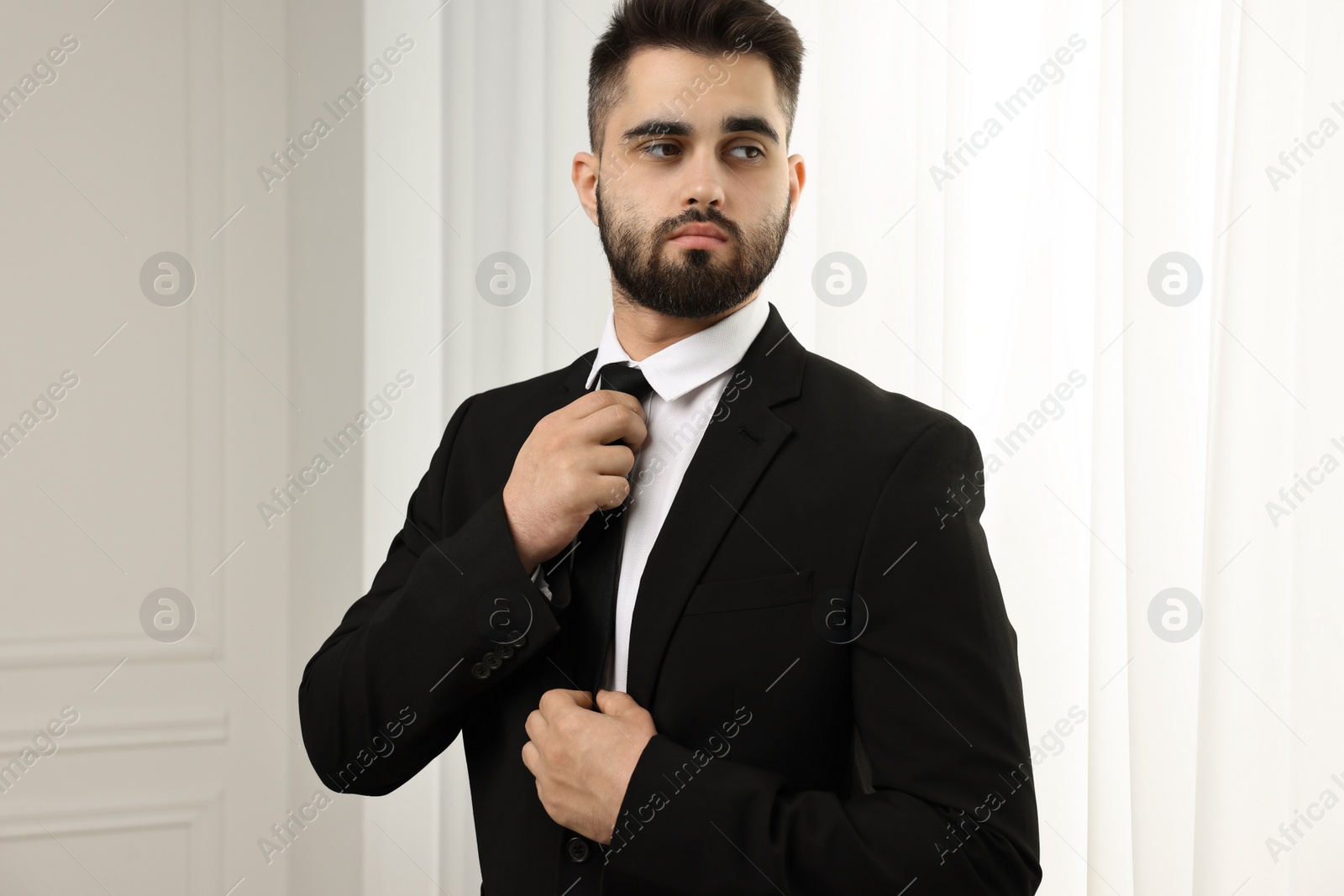 Photo of Handsome businessman in suit and necktie indoors