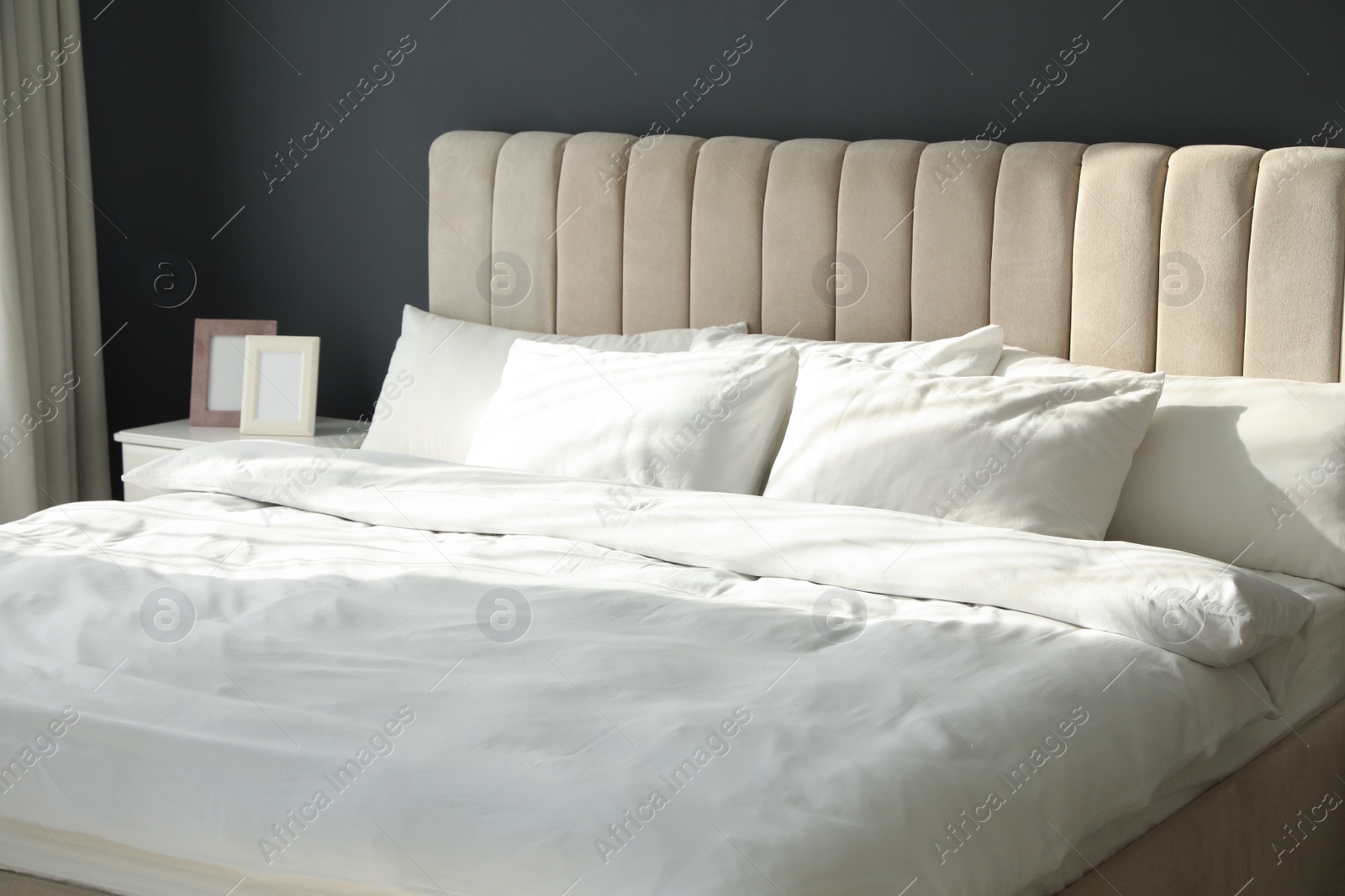 Photo of Comfortable bed with soft blanket and pillows indoors