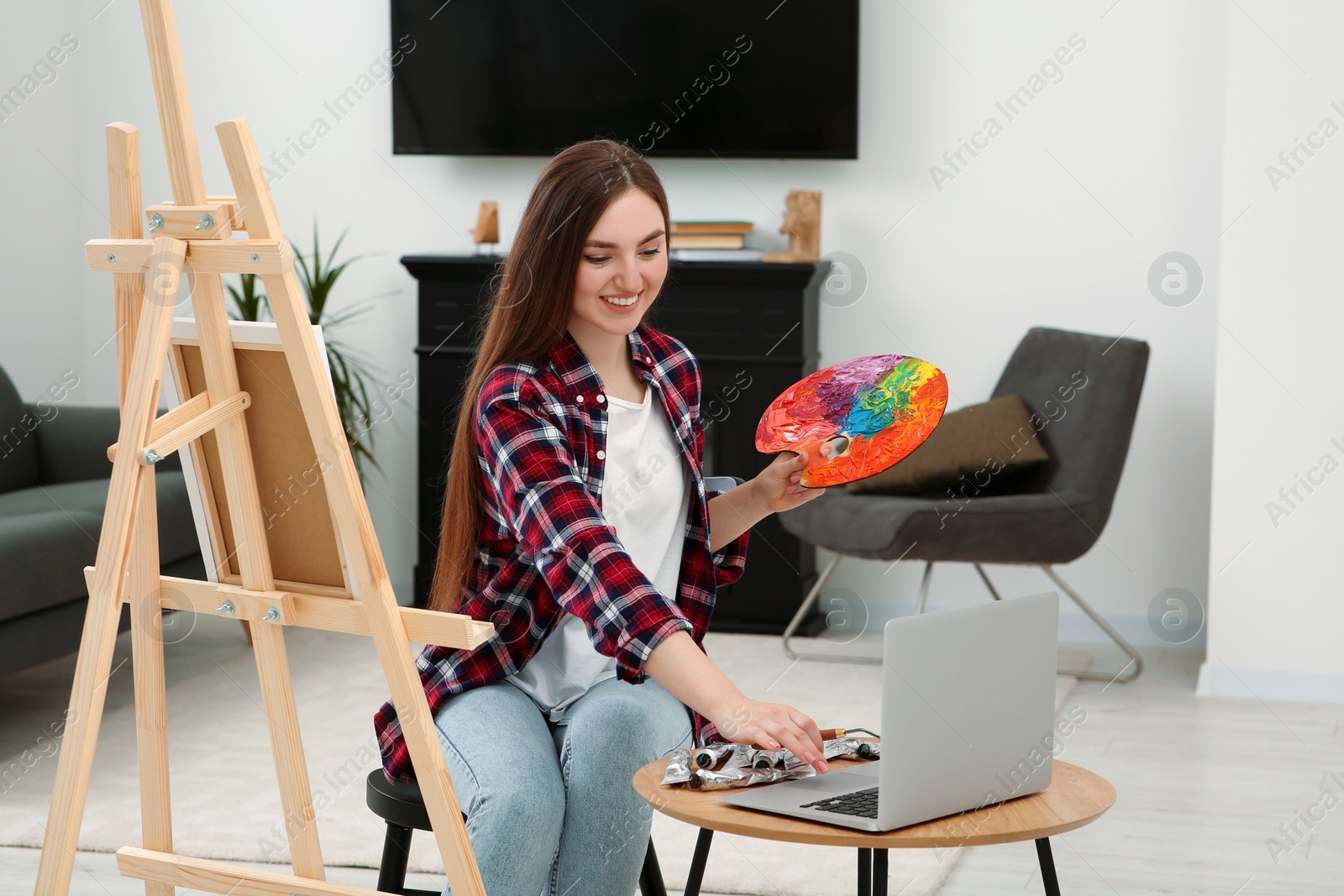 Photo of Woman learning to paint with online course at home. Time for hobby