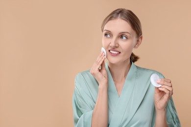 Photo of Young woman with cotton pads on beige background. Space for text