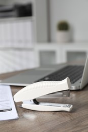 Photo of Stapler on wooden table indoors, closeup view