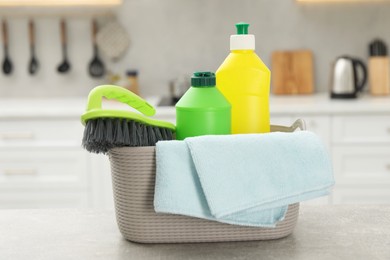 Photo of Different cleaning supplies in basket on table