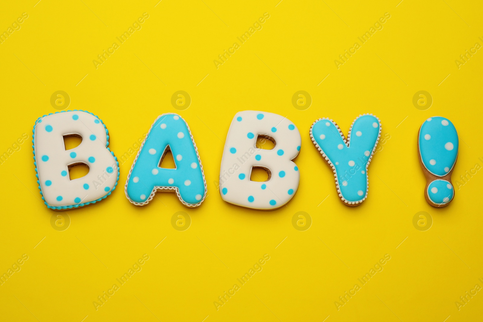 Photo of Word BABY made of tasty cookies on yellow background, flat lay