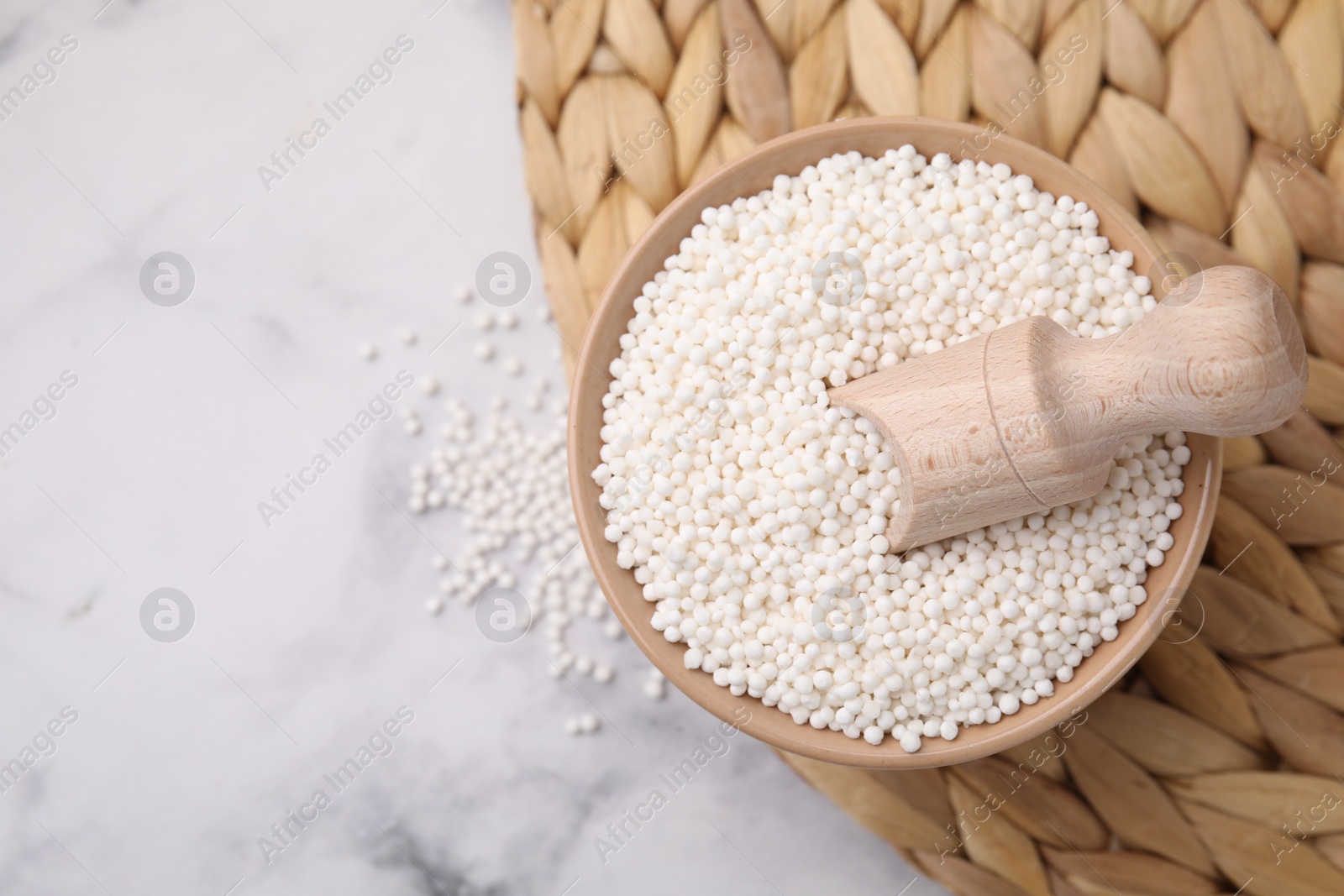 Photo of Tapioca pearls in bowl on white table, top view. Space for text