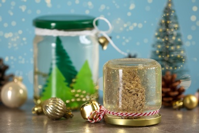 Handmade snow globes and Christmas decorations on table