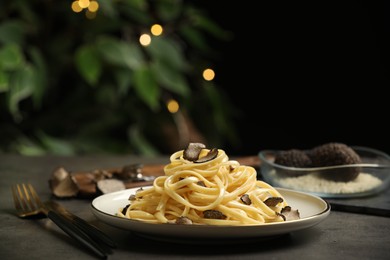 Photo of Tasty fettuccine with truffle on grey table