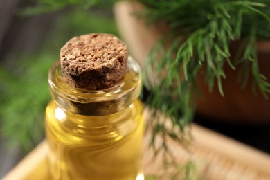 Photo of Bottle of essential oil and fresh dill on table, closeup. Space for text