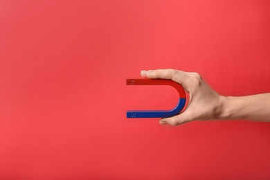 Photo of Woman holding magnet on color background, closeup. Space for text