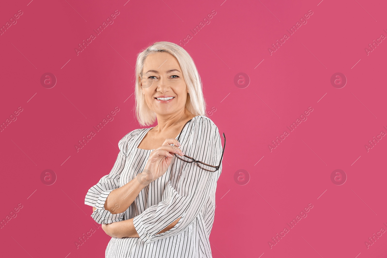 Photo of Portrait of beautiful mature woman with glasses on pink background. Space for text