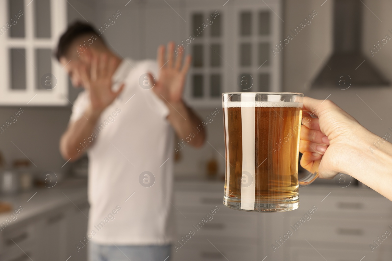 Photo of Man refusing to drink beer in kitchen, closeup. Alcohol addiction treatment