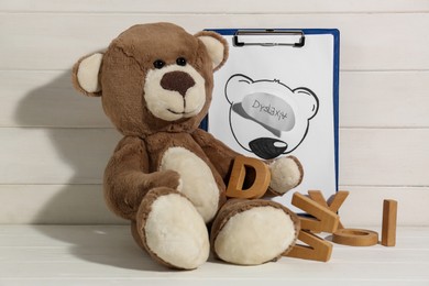 Clipboard with word Dyslexia, wooden letters and teddy bear on white table