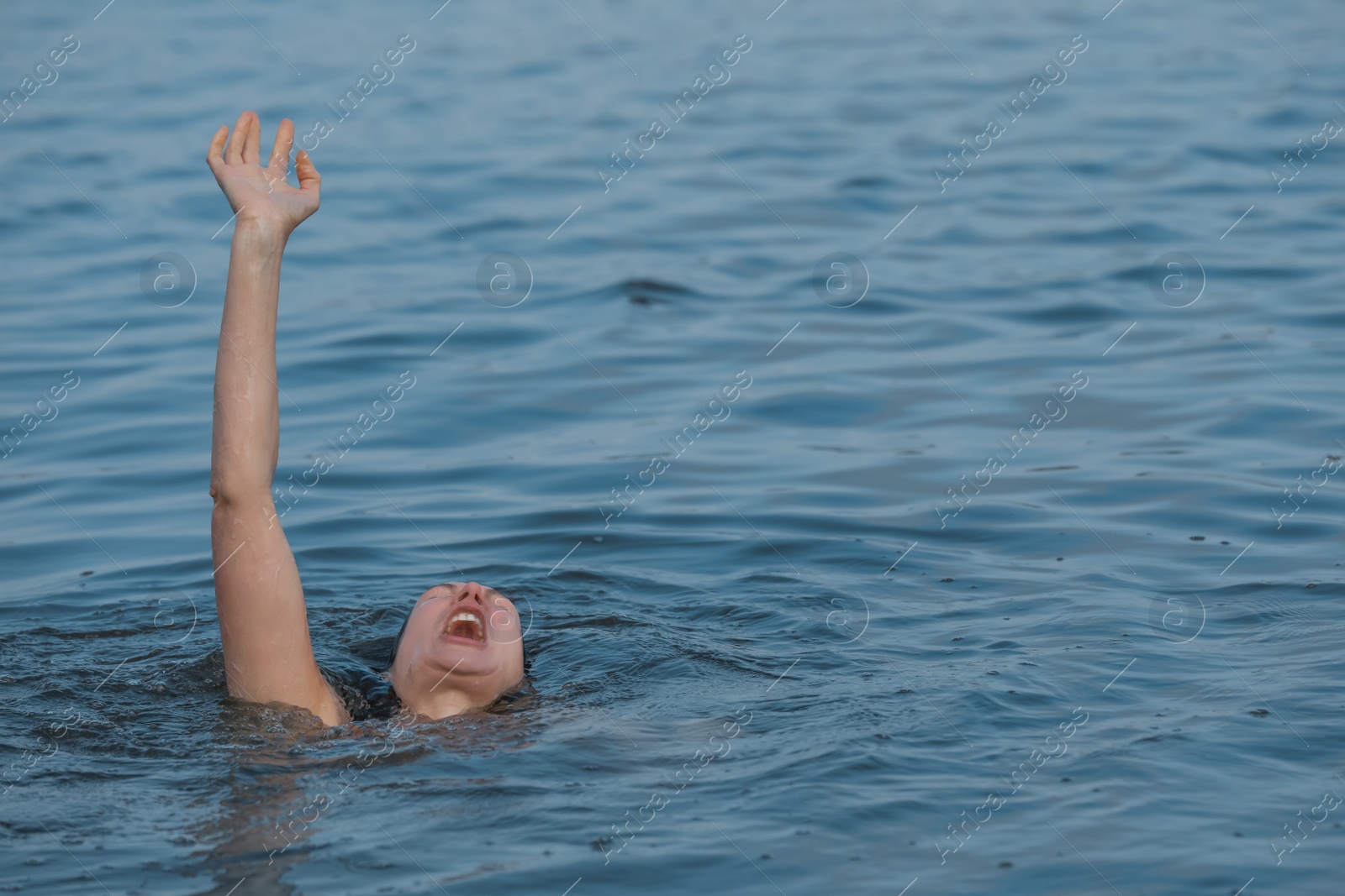 Photo of Drowning woman reaching for help in sea