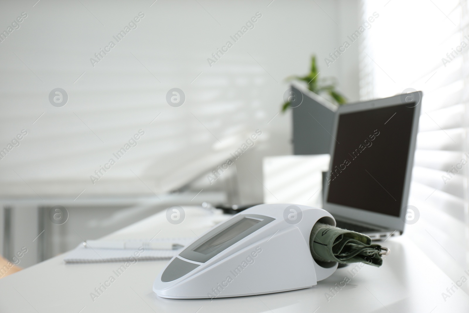 Photo of Digital blood pressure monitor on table in doctor's office