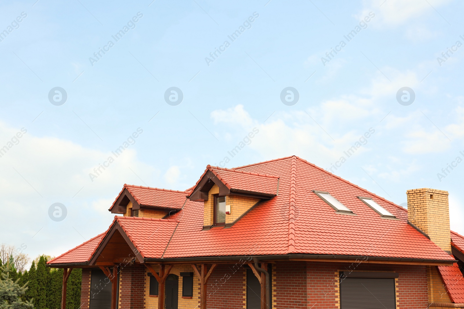 Photo of Modern house with red roof against cloudy sky