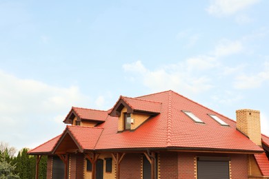 Photo of Modern house with red roof against cloudy sky