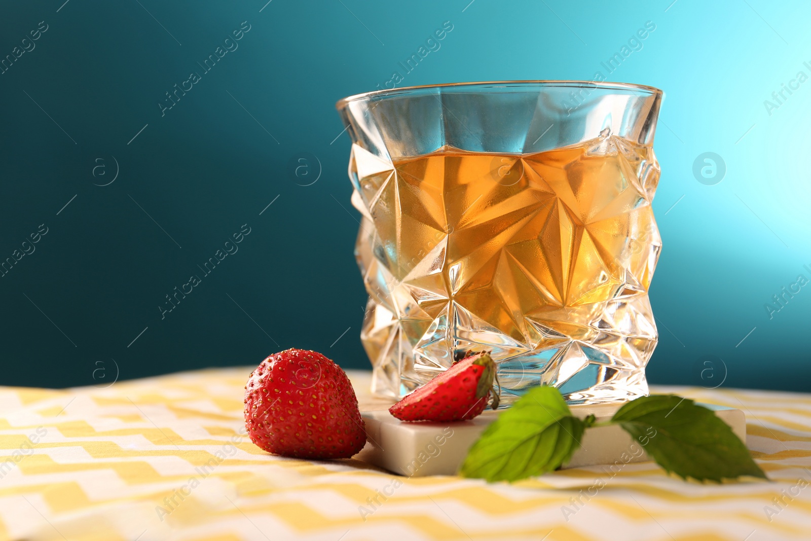 Photo of Glass of alcohol drink, strawberries and mint on table