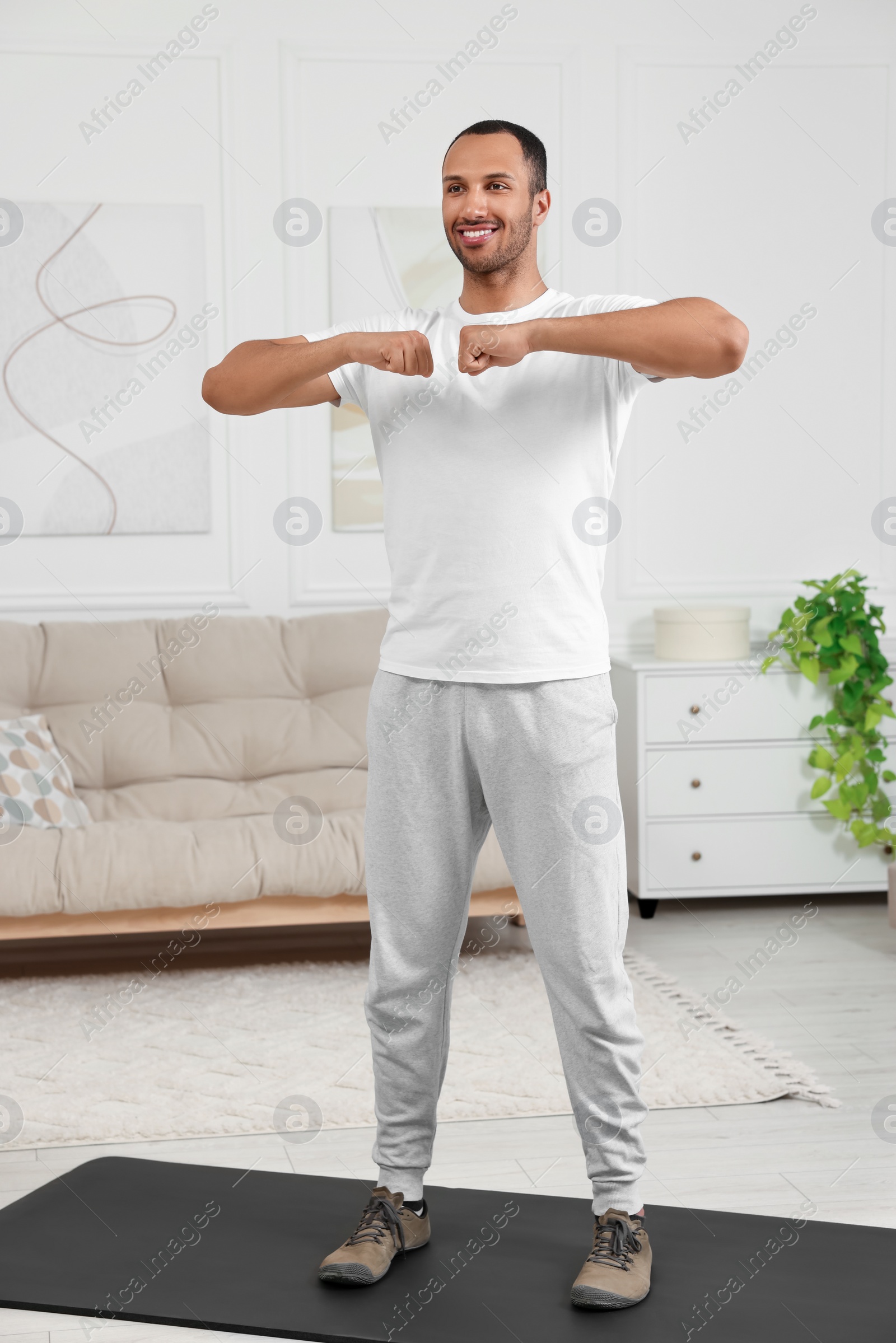 Photo of Man doing morning exercise on fitness mat at home