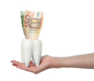 Photo of Woman holding ceramic model of tooth and euro banknotes on white background, closeup. Expensive treatment