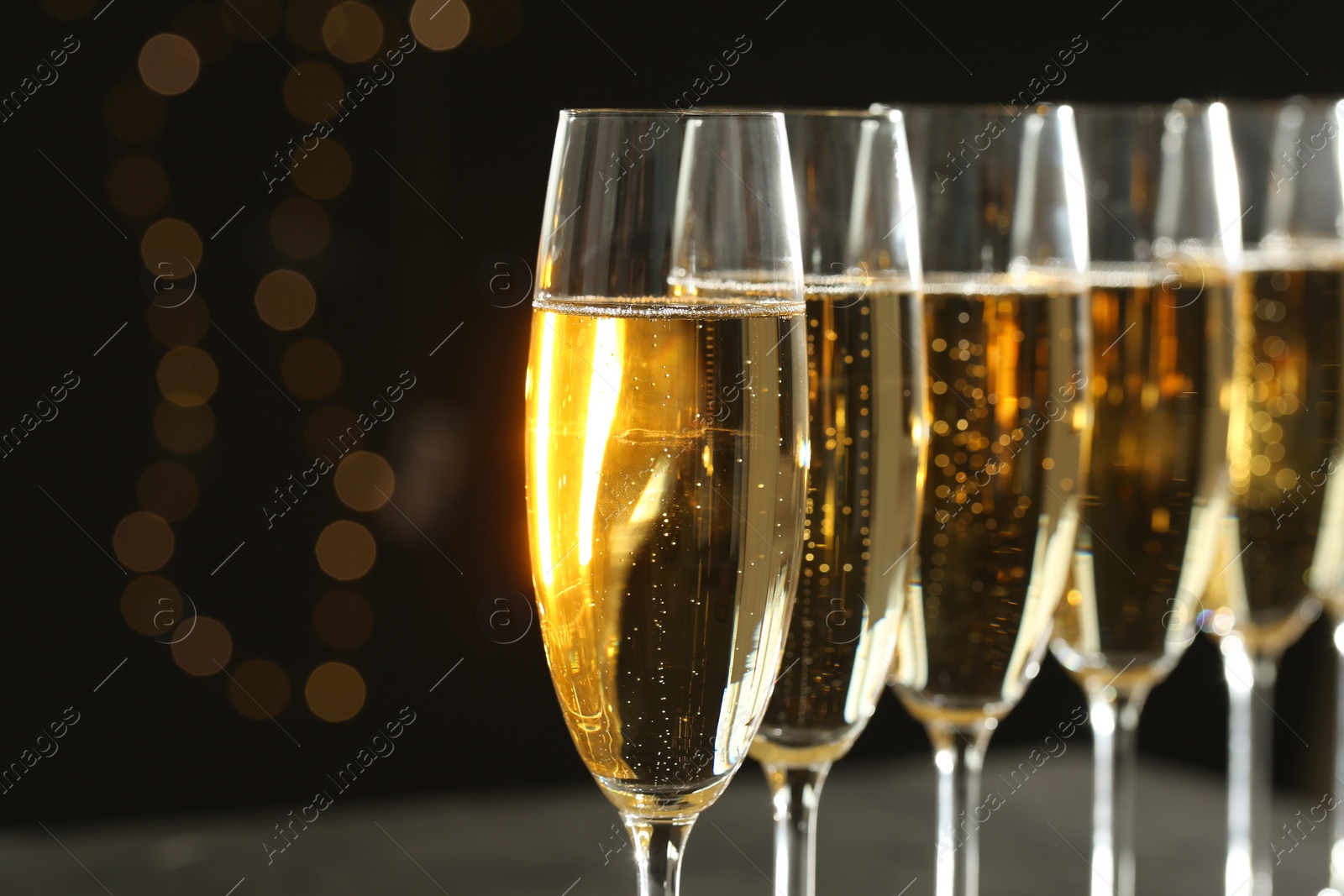 Photo of Glasses of champagne on blurred background, closeup. Space for text