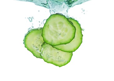 Photo of Fresh cucumber slices in water on white background