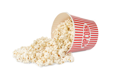 Photo of Overturned paper bucket with delicious popcorn isolated on white