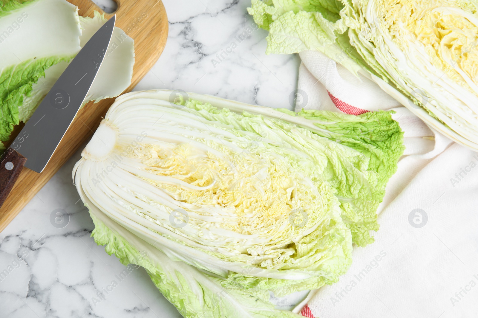 Photo of Cut Chinese cabbage on white marble table, flat lay