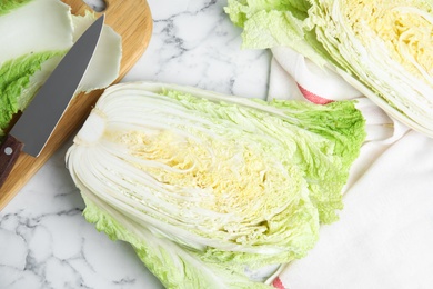 Cut Chinese cabbage on white marble table, flat lay