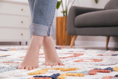 Photo of Woman standing on soft carpet at home, closeup. Space for text