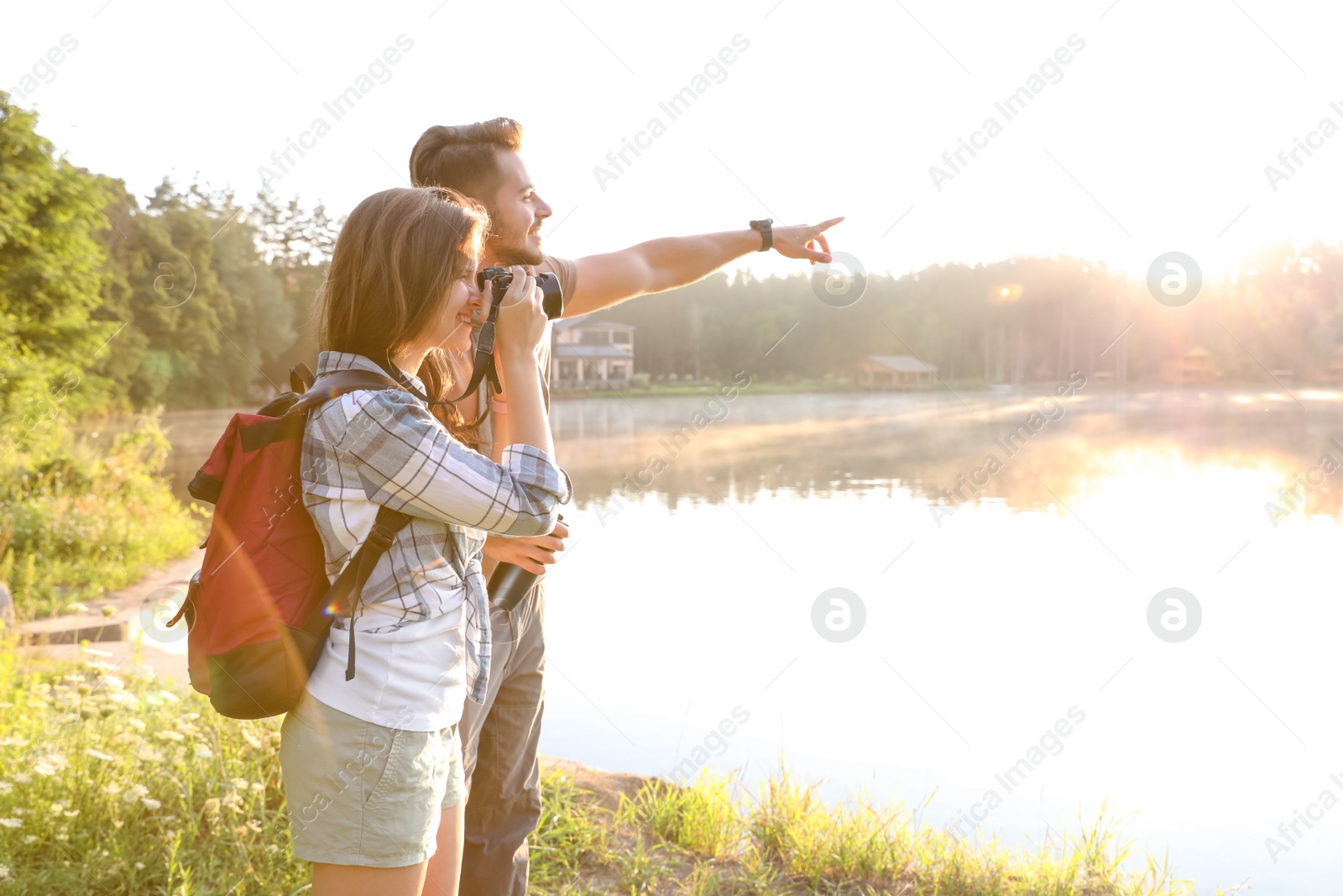 Photo of Young couple on shore of beautiful lake. Camping season