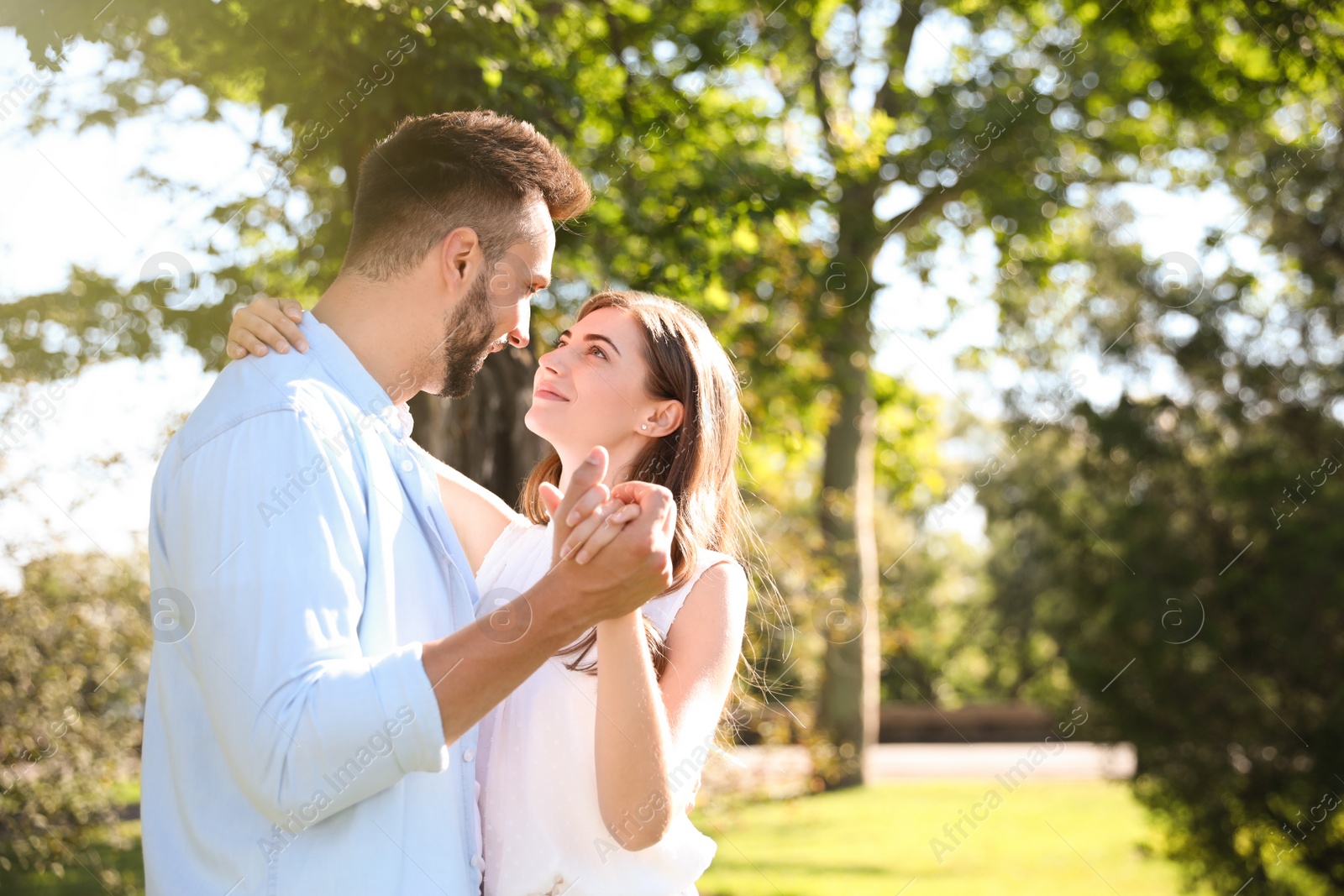 Photo of Lovely young couple dancing together in park on sunny day