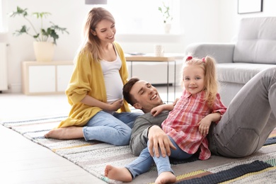 Young pregnant woman with her family at home