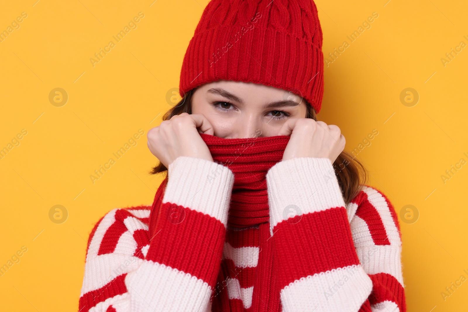 Photo of Beautiful woman in warm scarf on yellow background