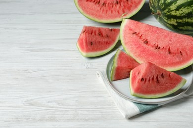 Photo of Tasty ripe watermelons on white wooden table, space for text